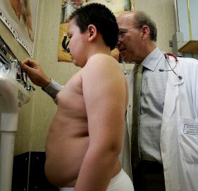 niño obeso pesado por un medico